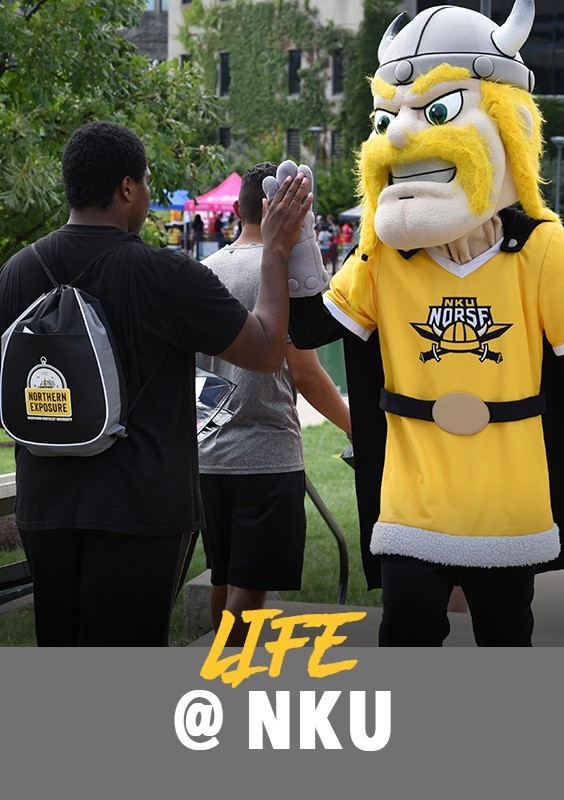 Life at ϳԹվ: Student at an event giving Victor E. Viking a high-five